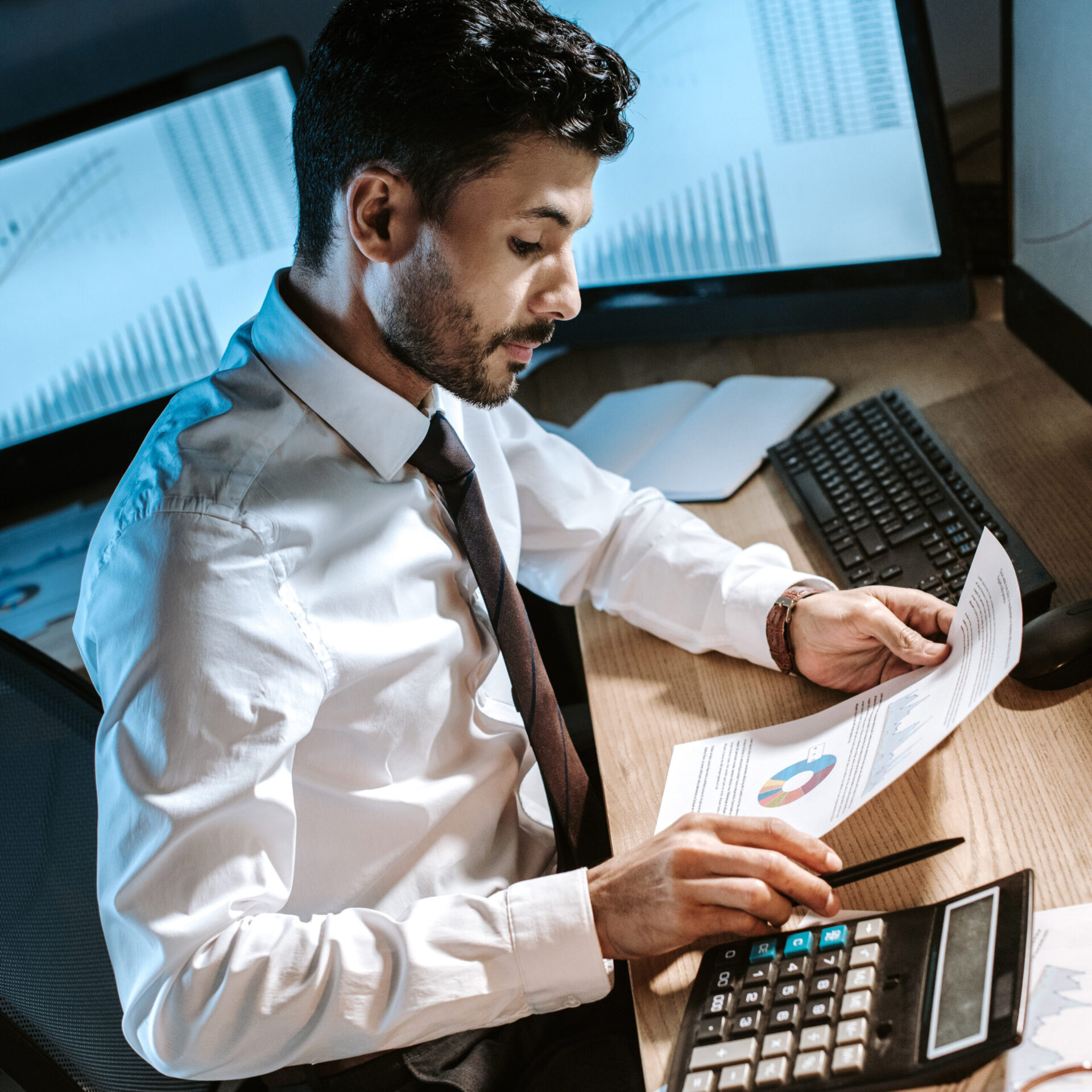 high angle view of bi-racial trader looking at paper and sitting at table